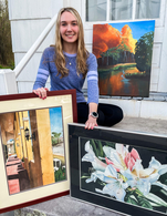 Abbey Stokes Sitting On Steps Outside With 3 Of Her Paintings